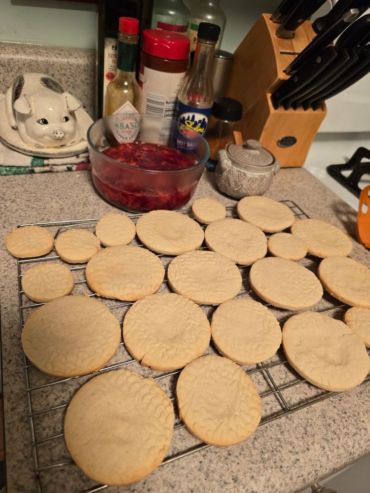 Shortbread cookies with strawberry topping in a bowl behind them