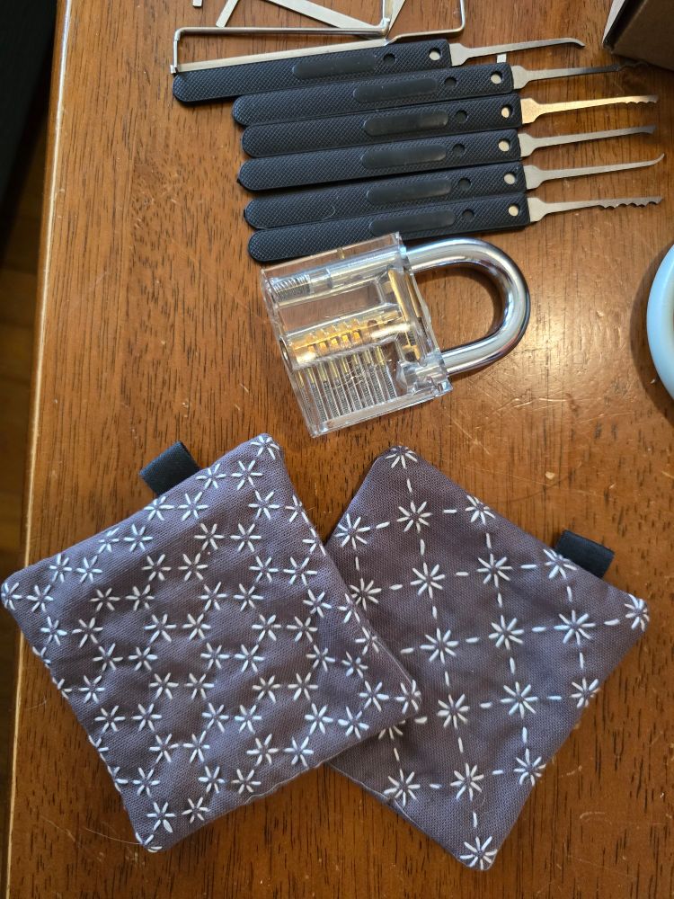 Two sashiko-embroidered coasters and a lockpicking set placed on a table.