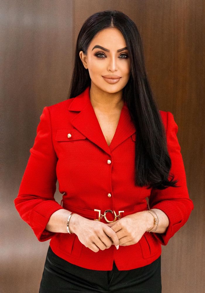 Image shows Liberal leadership candidate Ruby Dhalla in a red blazer with a face that is as smooth and blurred as a stick of butter. We’re talking a whole different face here. She looks like she stole Kylie Jenner’s face from 2016 and smeared Vaseline over the camera lens before taking her picture 
