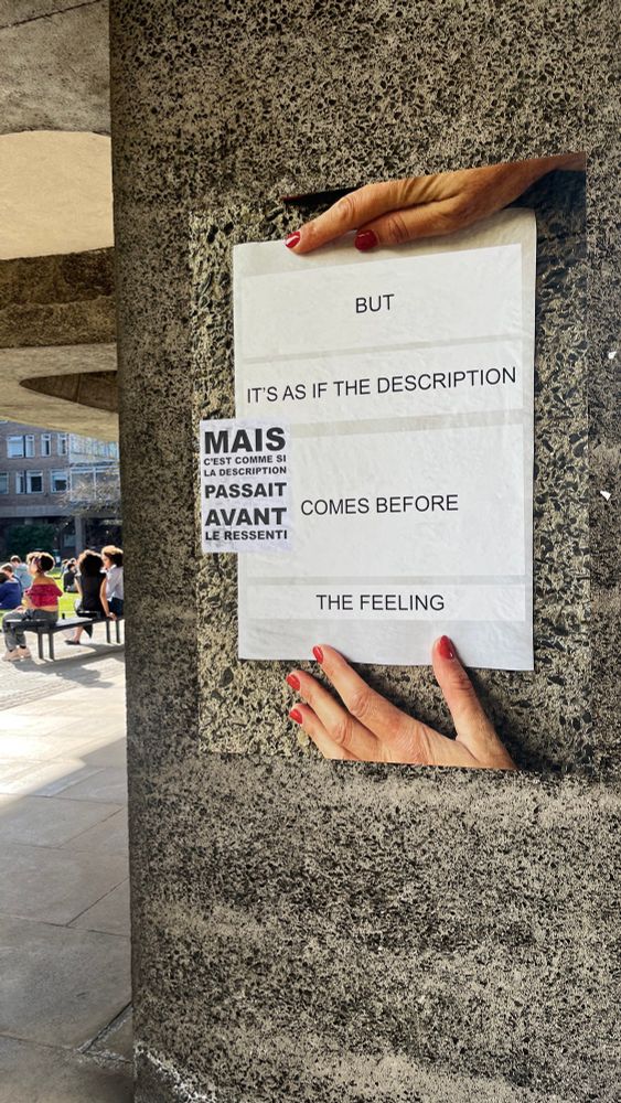 On another concrete pillar of the Raised Faculty Building, a large poster in English reads “But it’s as if the description comes before the feeling”. A smaller poster in French reads “Mais c’est comme si la description passait avant le ressenti”.