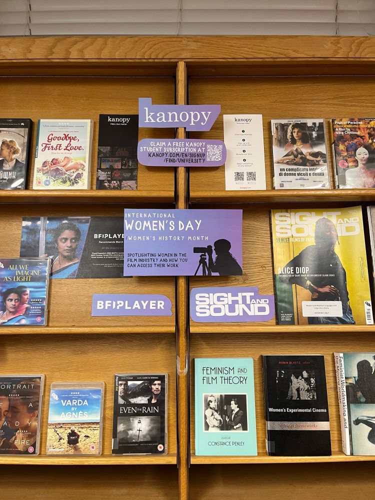 A photo of the exhibition space in the MMLL Library Foyer. On the bottom shelves are two rows of DVDs by women filmmakers, above are shelves highlighting the platform BFI Player and the journal Sight and Sound. One copy of Sight and Sound highlights Alice Diop, and another is open on a page about motherhood in films. On the top row of the display are more DVDs, as well as information about the  streaming platforms Klassiki and BoB.