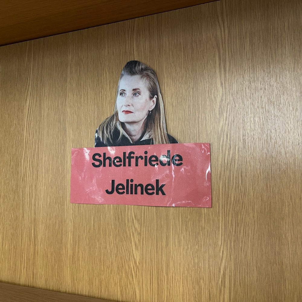 A bookshelf in the MMLL Library foyer, with a label reading 'Shelfriede Jelinek'