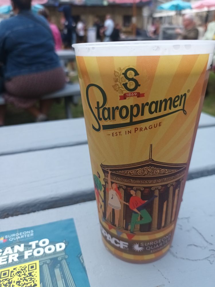 A plastic Staropramen-branded pint cup