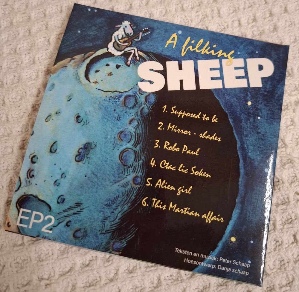 Cover of EP2: a filking sheep. Design by Danja Schaap. 
A guitar playing sheep on the edge of a crater on a small Moon.