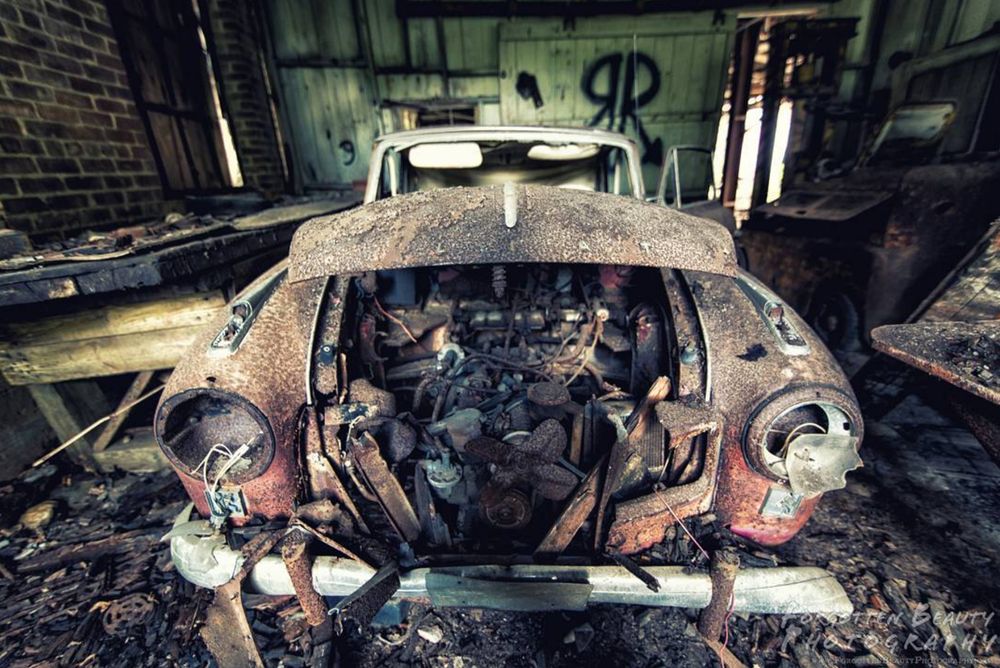 A photo of a destroyed, abandoned car.