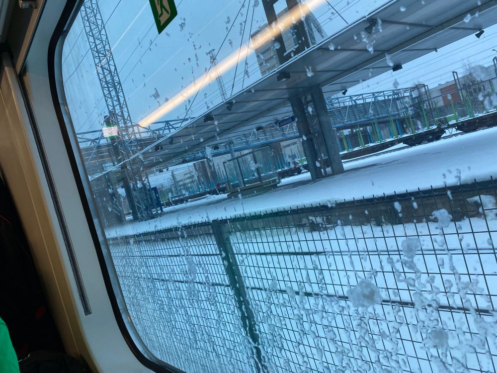 An Image of inside a train in Jyväskylä, about to depart. It's snowing outside.