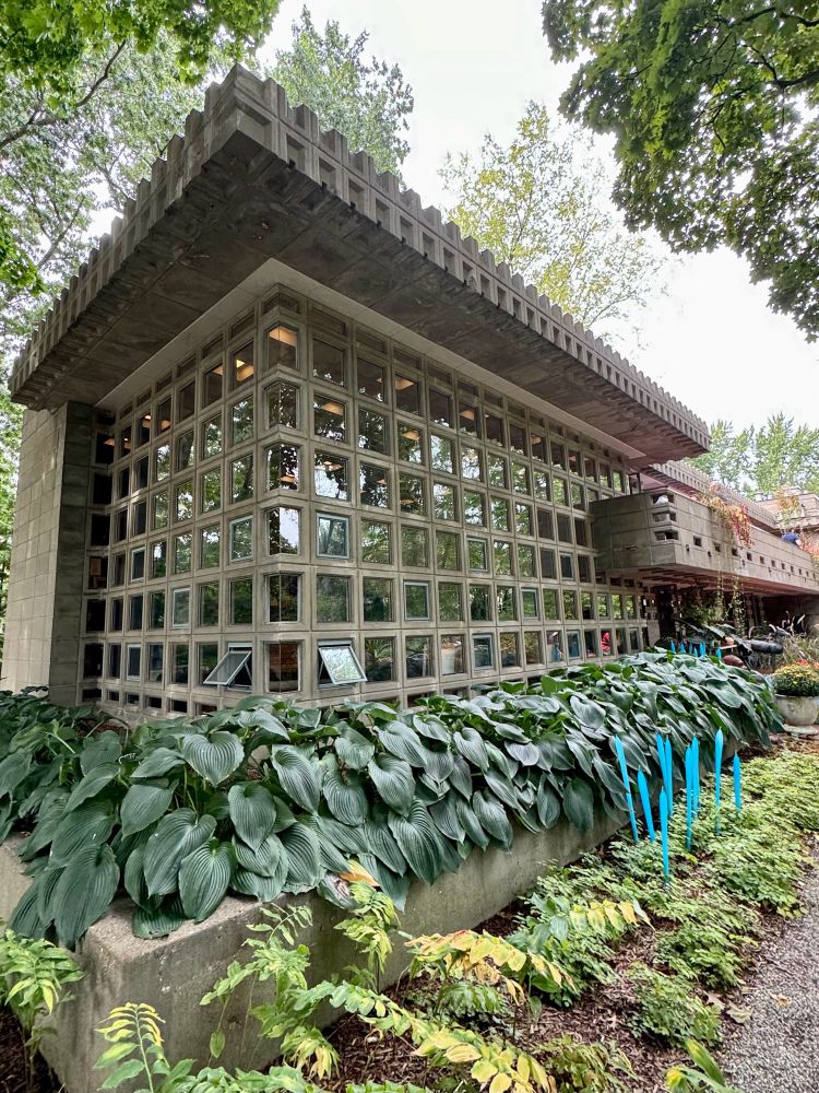 Concrete block house with tall wall of square windows. 