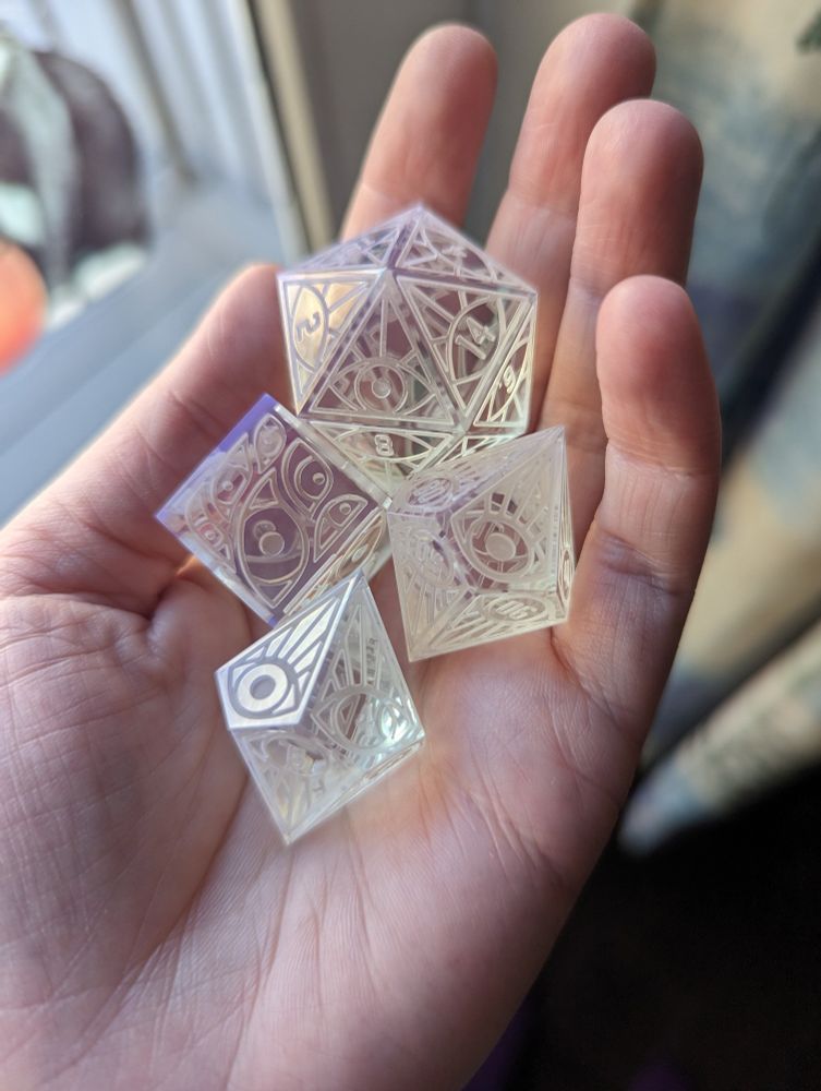 A handful of polished dice masters with an eye design.