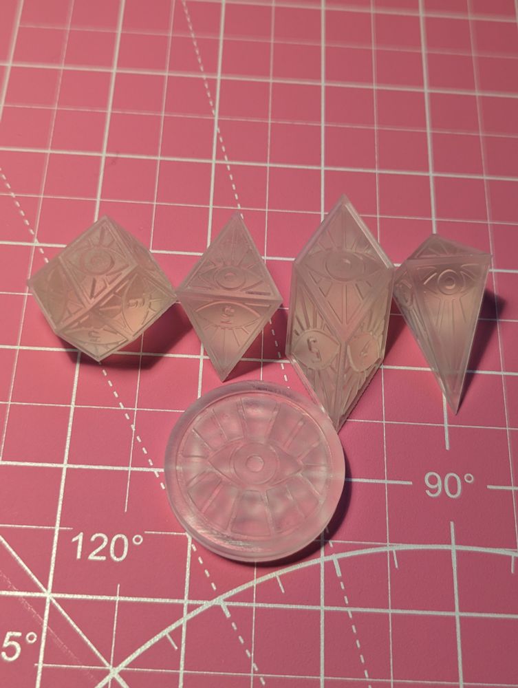 Eye patterned dice masters on a cutting mat. They are unsanded and unpolished.