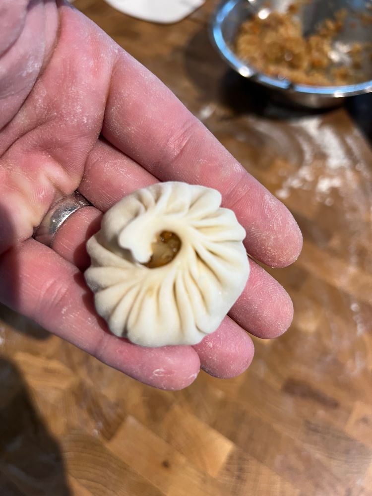 A dumpling in my hand, before being steamed
