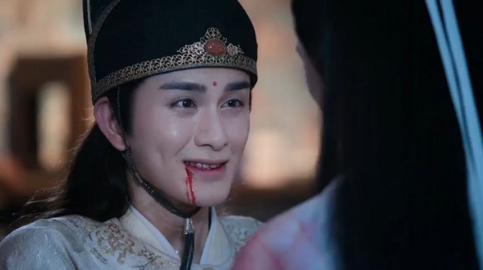 A screenshot of actor Zhu Zanjin as Jin Guangyao, in episode 50 of xianxia series "Chen Qing Ling"/"The Untamed." His teeth are blood-stained, and blood trickles from his mouth as he smiles at Lan Xichen, on realising that the answer to his plea of "stay and die with me" is "yes." (He then pushes Lan Xichen away.)
