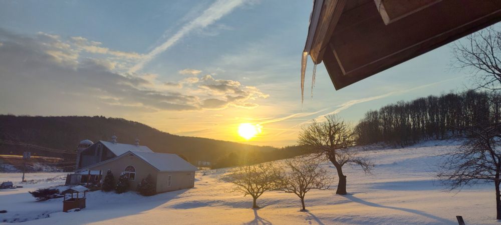 Sunrise over snow covered barn 