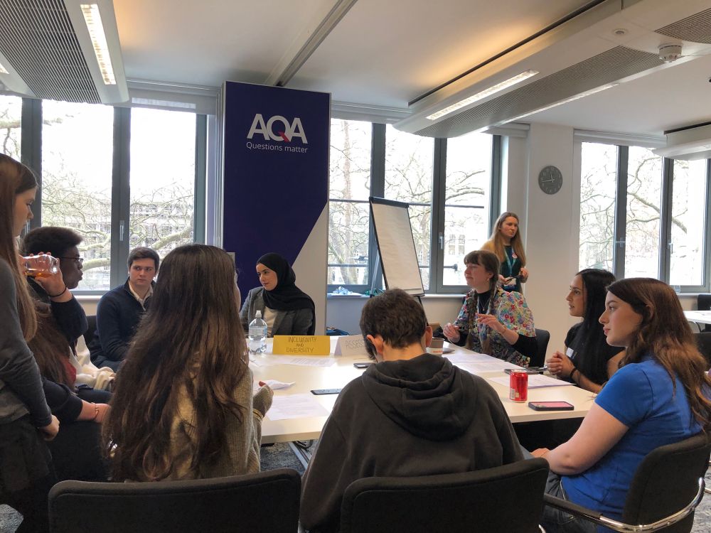 A second group of students sit around a table discussion solutions to issues in their education.