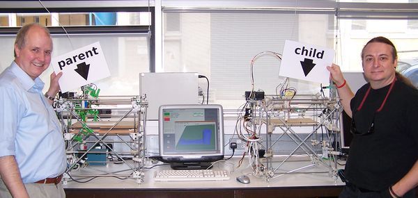 RepRap 3D printer on the left (parent), and the RepRap 3D printer on the right (child) that it printed the parts for. Adrian Bowyer and Vik Olliver of the RepRap Project also in the picture. 14:00 hours UTC on 29 May 2008.