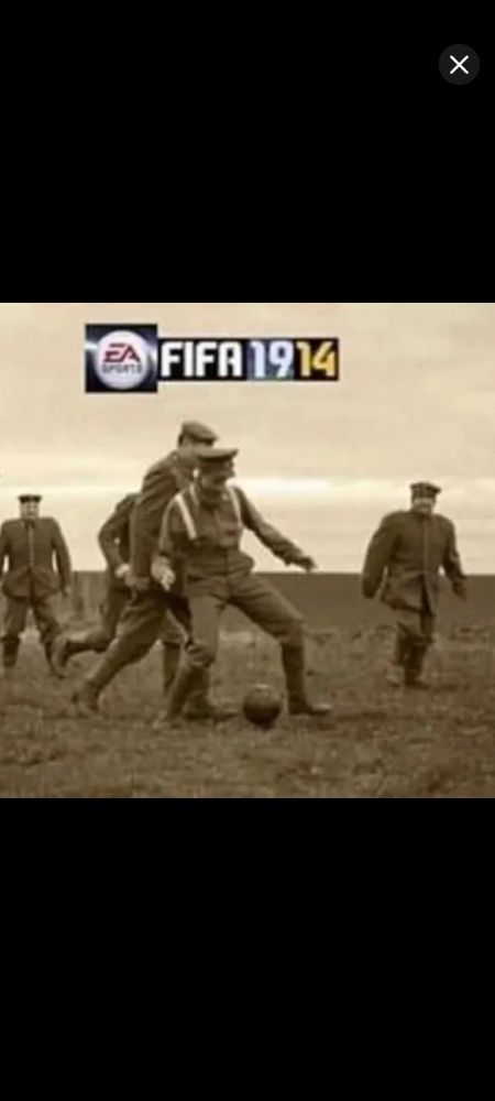 A sepia toned photograph showing world war one soldiers, probably British, playing football. Text above is cut from the titles of several FIFA games to say "EA Games FIFA 1914"