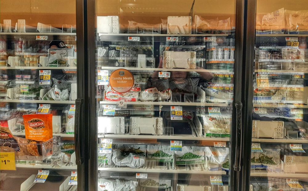 Image of freezer section with vegetables about half depleted.