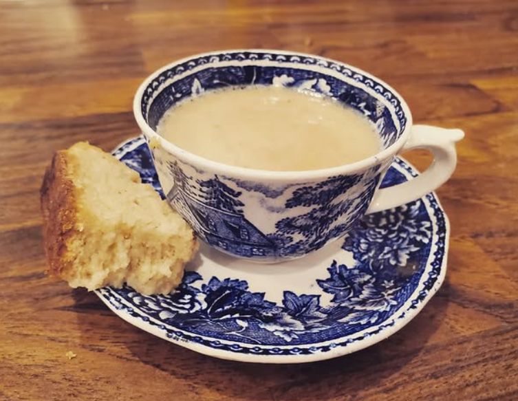 blue and white demitasse filled with hot chocolate with a piece of biscotti on the saucer