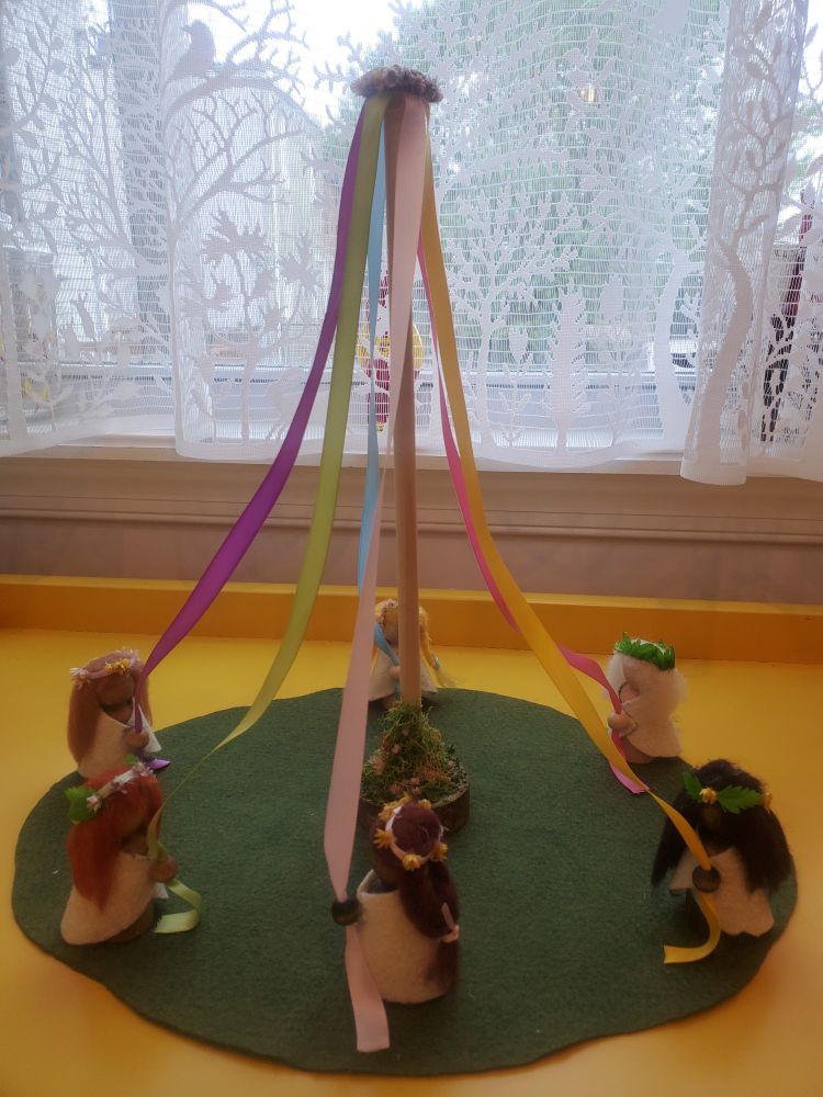Miniature may pole with six peg dolls dancing around it, all with different colored ribbons