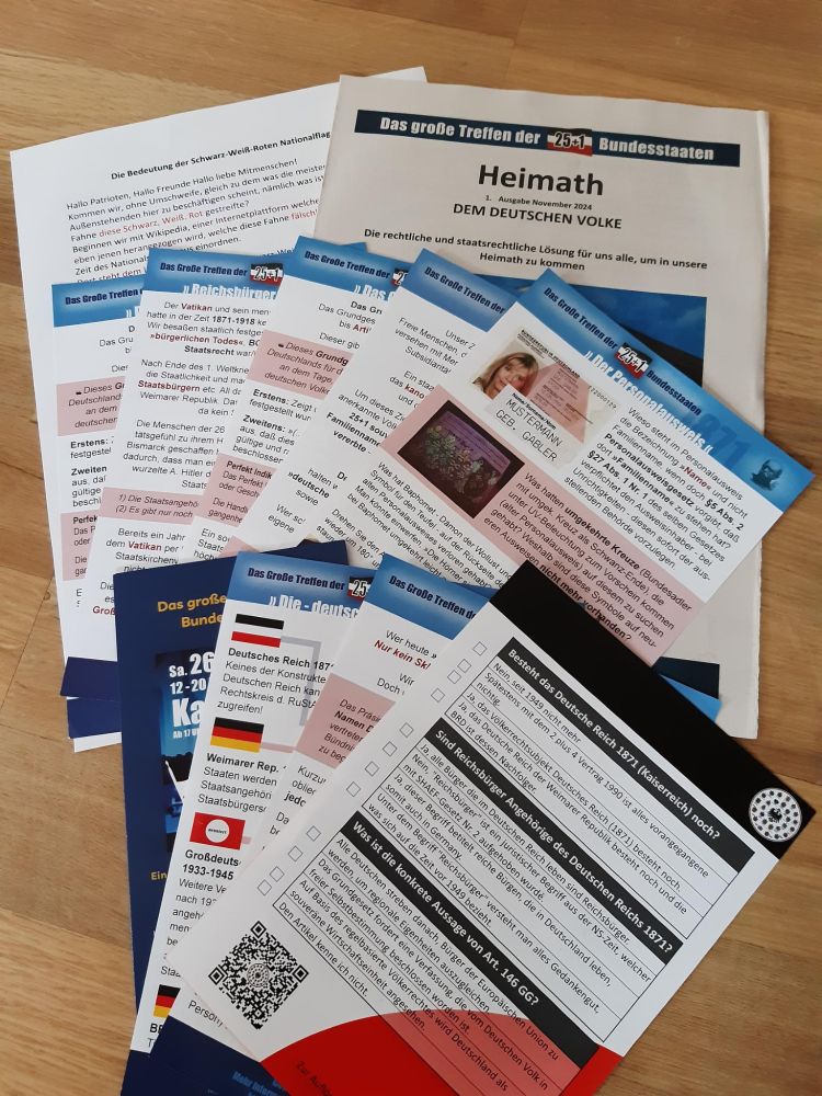 Zu sehen sind verschiedene Flyer, ein Infoblatt und eine Zeitung zum "25+1 Bundesstaaten"-Treffen, die am Infostand verteilt wurden.