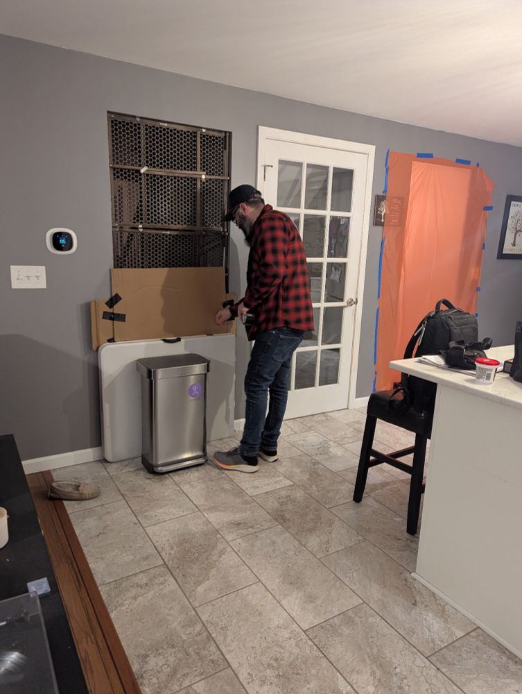 It's a picture of me looking like a hipster Doofus, putting baby gates, cardboard, a folding table, and a garbage can in a doorway to prevent escape