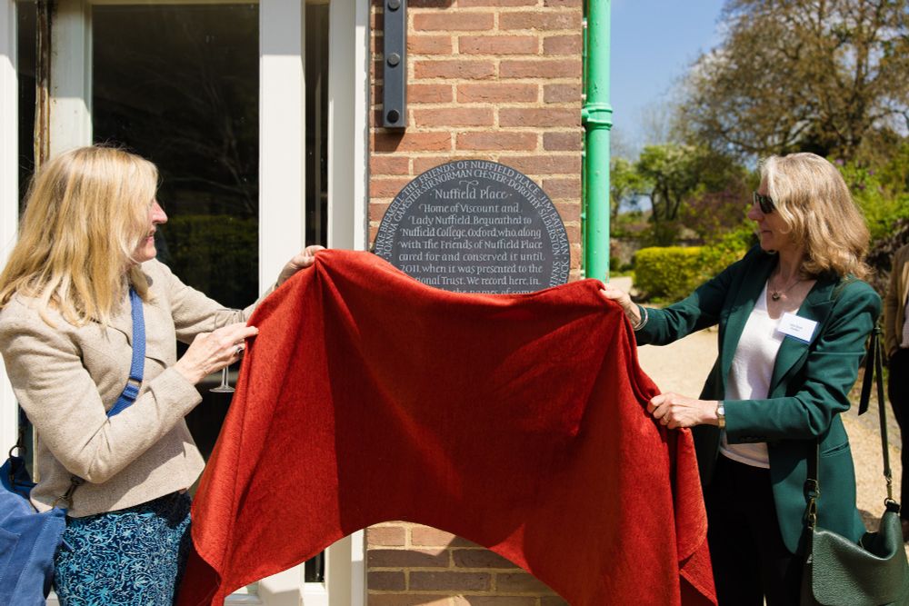 Joanna Gamester, House Steward of Nuffield Place for many years, and the Warden unveiling the commemorative plaque. Credit: Tom Weller. 
