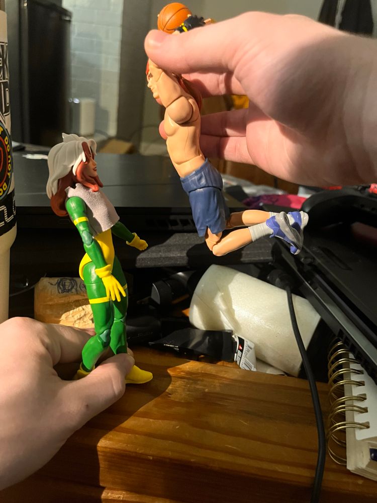 me and my gf posing our rogue and gambit figures to look like gambits boutta dunk his basketball directly onto rogues head  
