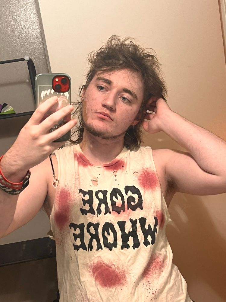 me, brown haired hick w a scraggly beard and freckles. torn up white tank stained with fake blood that says GORE WHORE