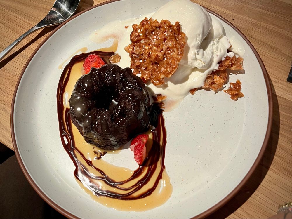 A plate of sticky toffee pudding with gelato and caramel.