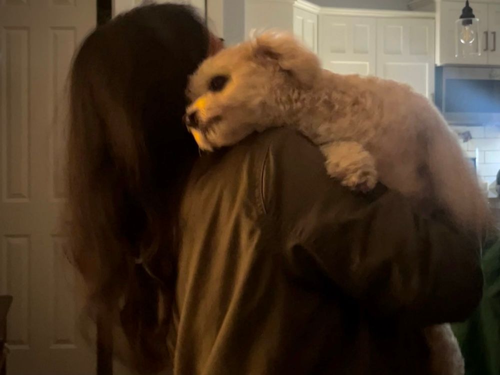 Dog laying its head on a girl’s shoulder.