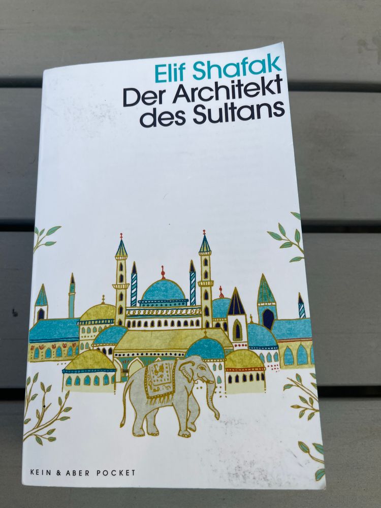 Cover des Romans „Der Architekt des Sultans“ von Elif Shafak.
Auf dem Cover ist eine gezeichnete alte Moschee zu sehen, vor der ein Elefant her läuft 