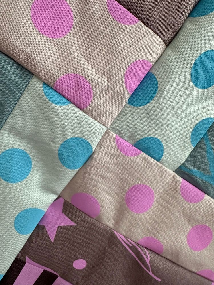 Blue and purple polka dot fabric coming together to make right angles. 