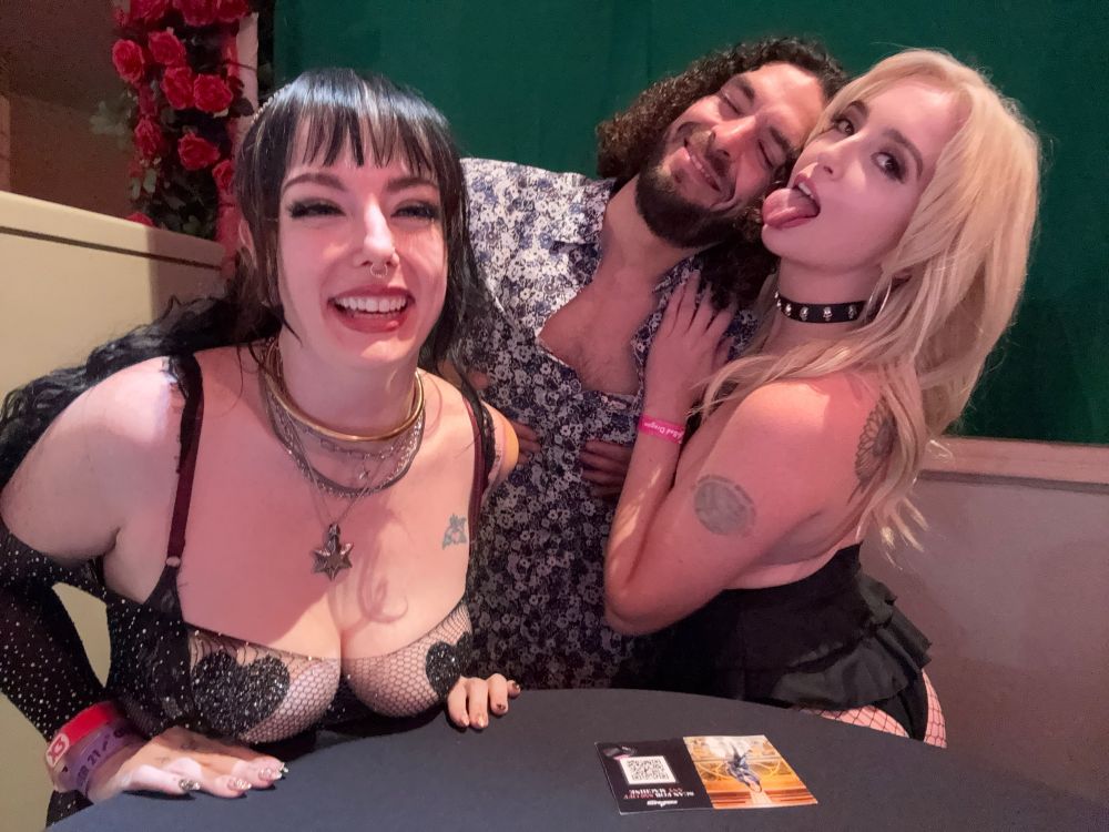Lily Obscura, Lexi Lore, and Mr. Perfect Porridge laughing and smiling behind a booth at X3
