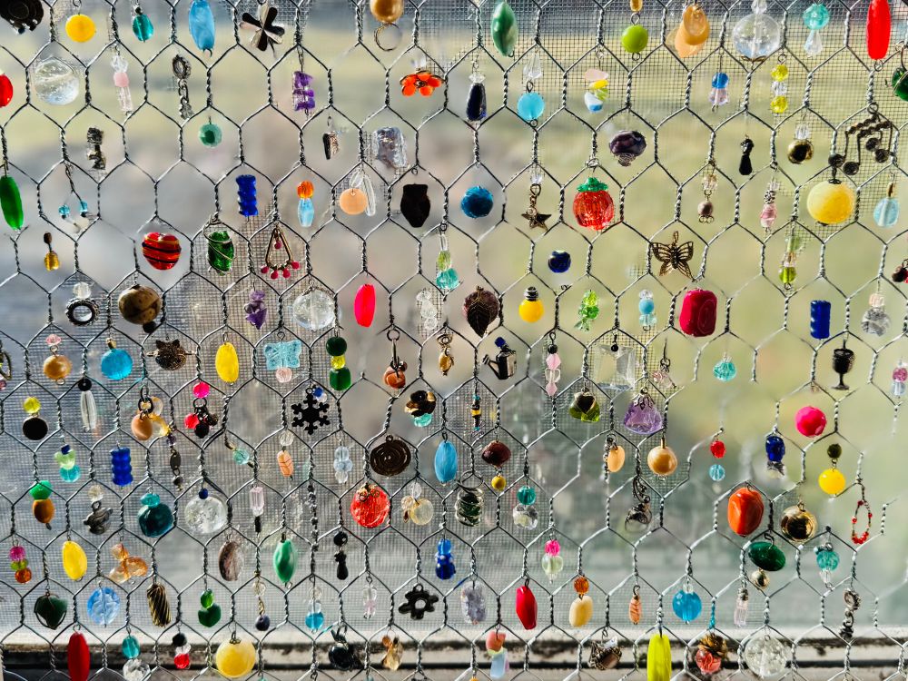Beads hanging from chicken wire frame.