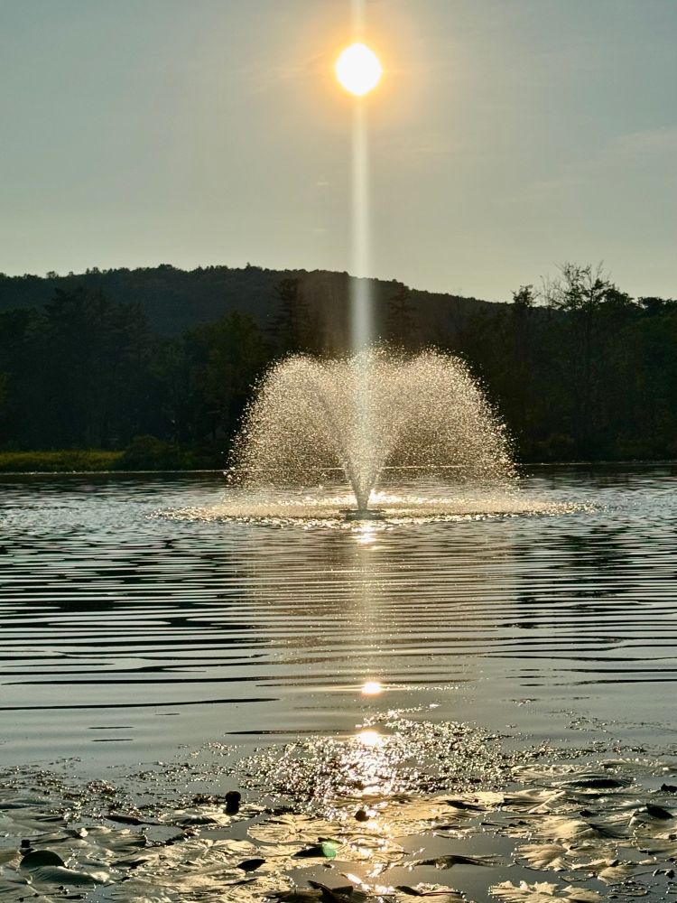 Sunbeam on fountain over Nichols pond