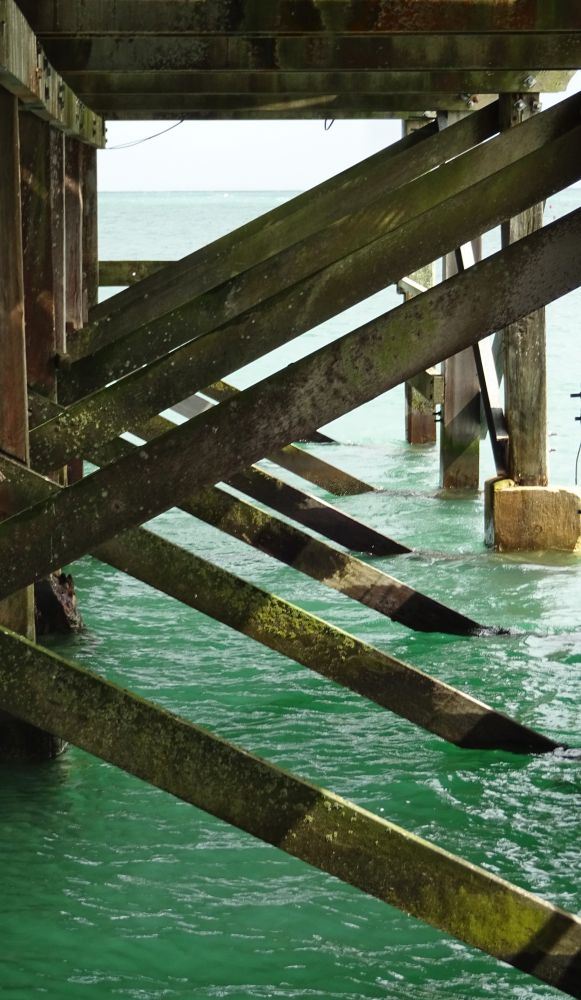 The angled struts of a pier, under the platform. 