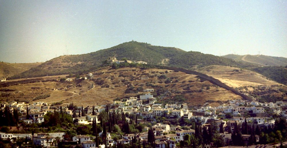 A wooded hill, behind an ecclesiastical building.