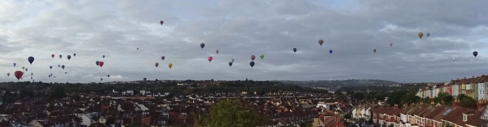 A panorama - a sky full of colourful hot-air balloons.