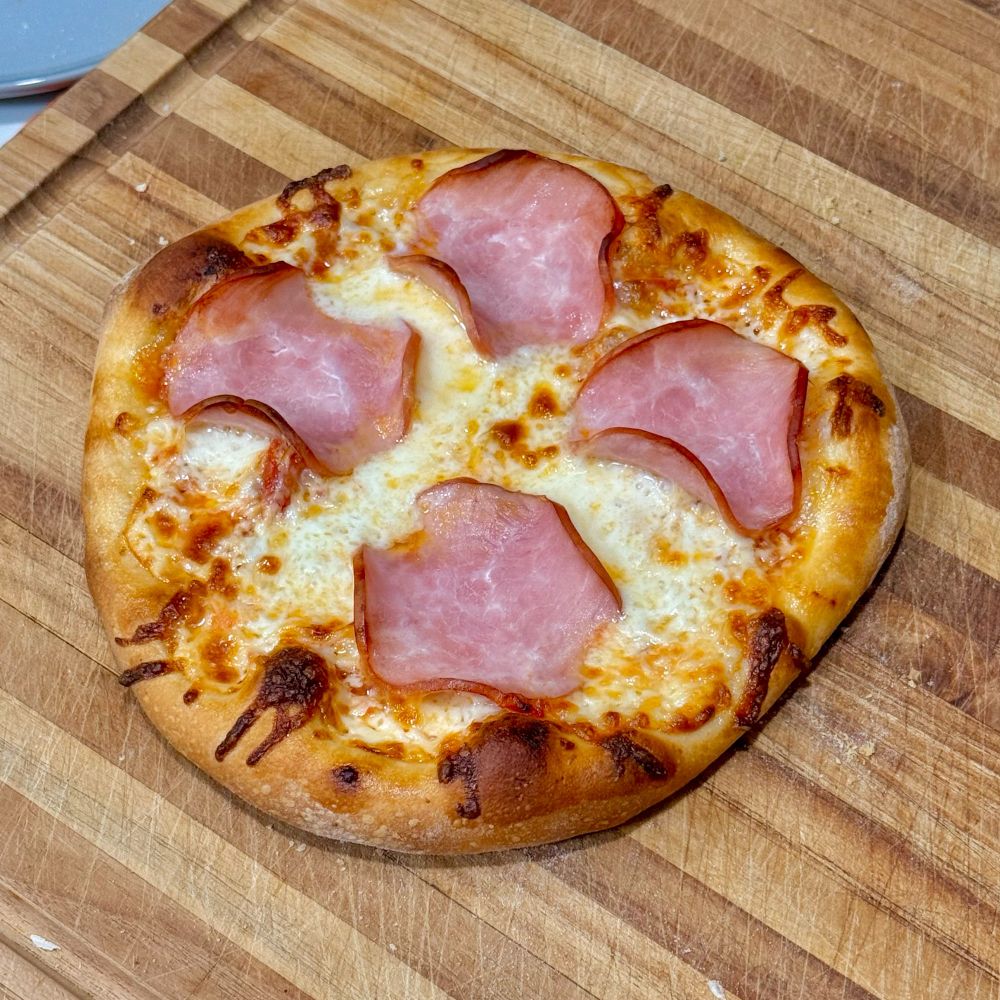 Homemade pizza with Canadian bacon. The pizza is roughly 12 inches in diameter. 