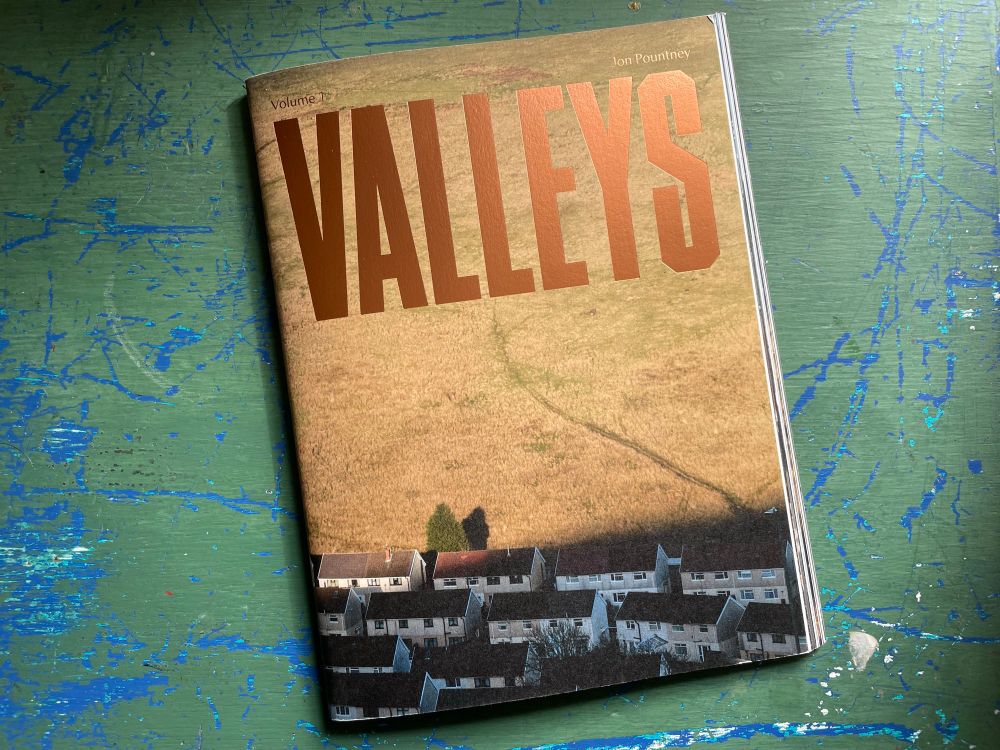 Valleys photography book on a green and blue painted desk