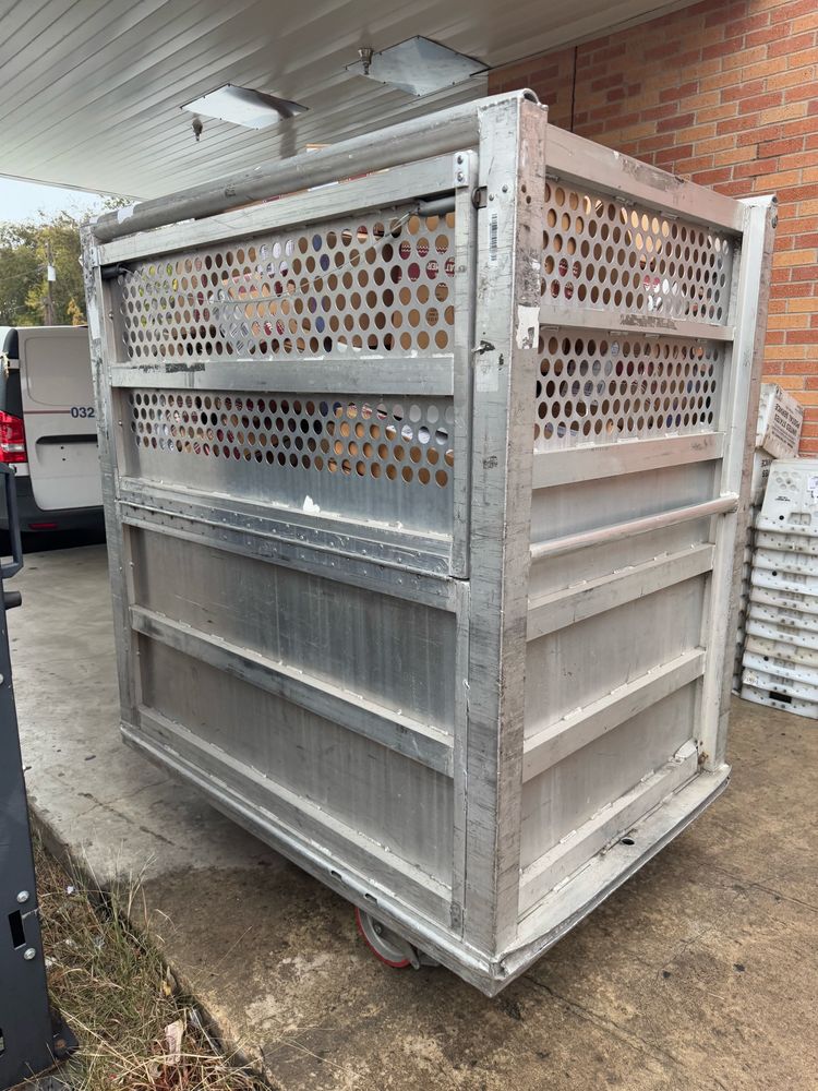 Photograph of large metal rolling container filled with packages