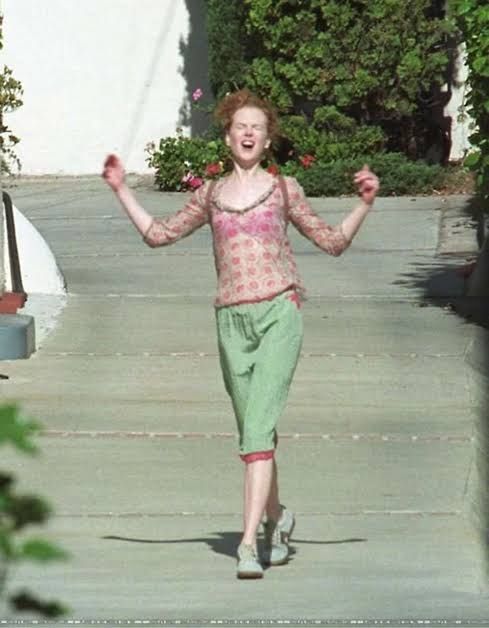 Foto da Nicole Kidman após assinar o divórcio de tom cruise andando no sol com os braços abertos 
