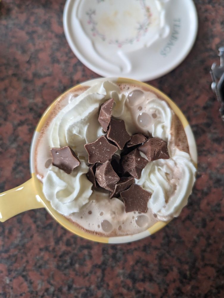 Milky Way Magic Stars topped Hot Chocolate in a Yellow Mug.