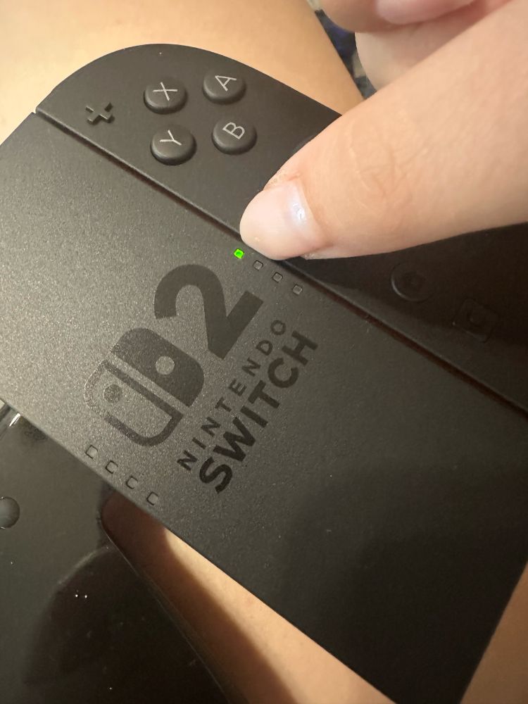 A very nicely manicured nail caught in the Nintendo switch 2 controller being clicked into the holster 