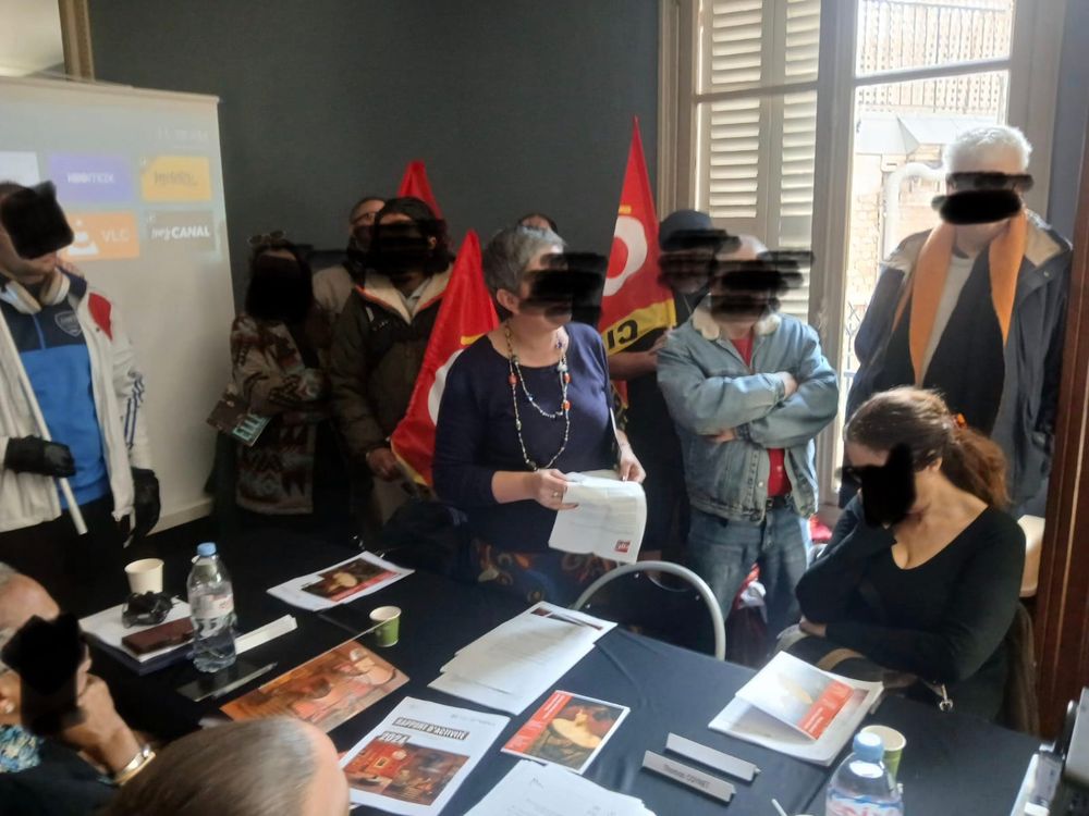 Des drapeaux CGT encadre des personnes veneres er deter qui lisent une déclaration au conseil d'administration 