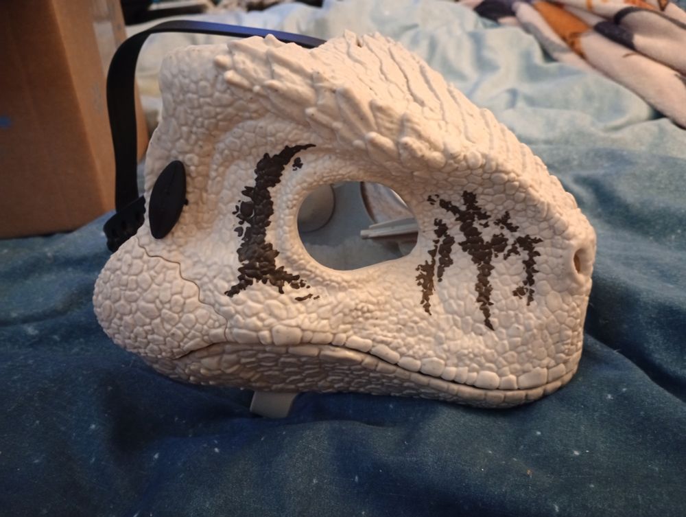 Atrociraptor dino mask side view. It's white with black stripes for now