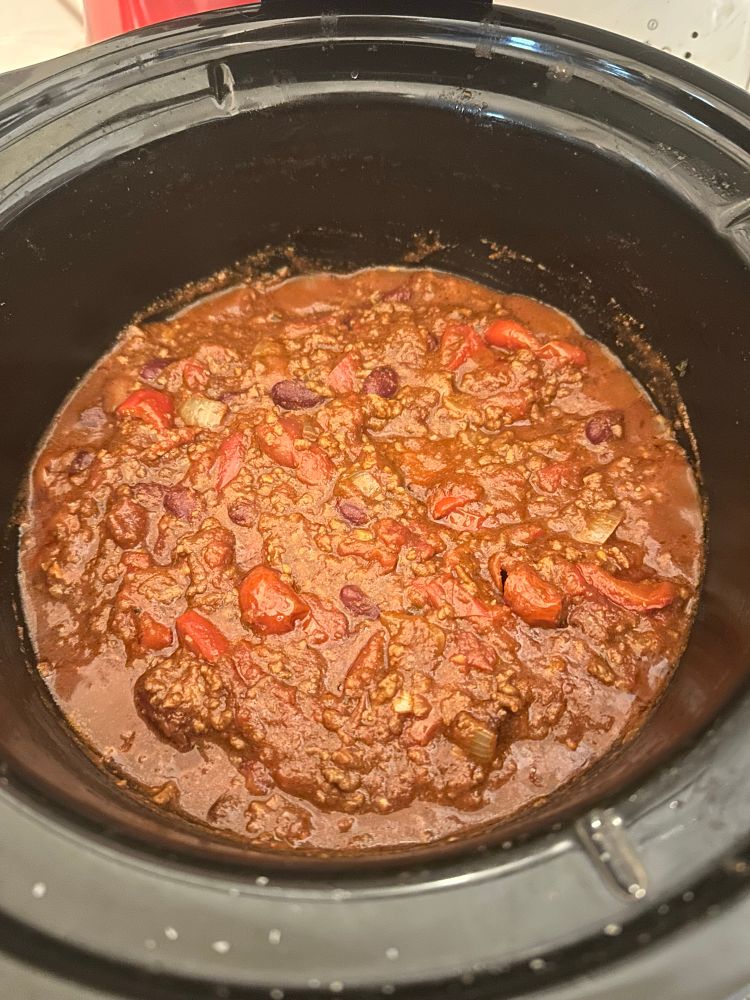 Chilli con carne bubbling away in a black slow cooker pot. Recipe here: https://www.recipetineats.com/chilli-con-carne/