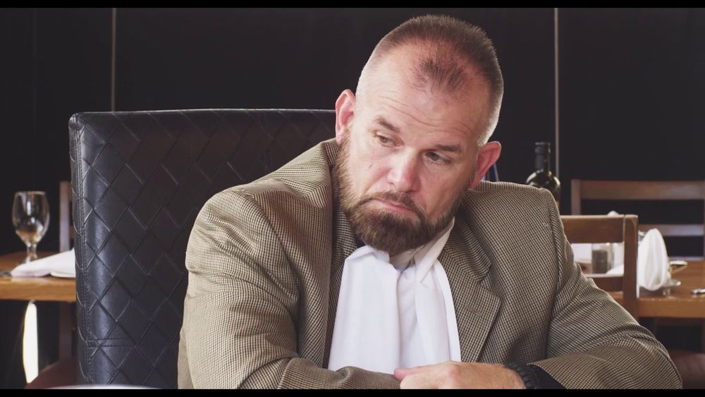 Image d'un homme de main qui n'a pas l'air sympa.