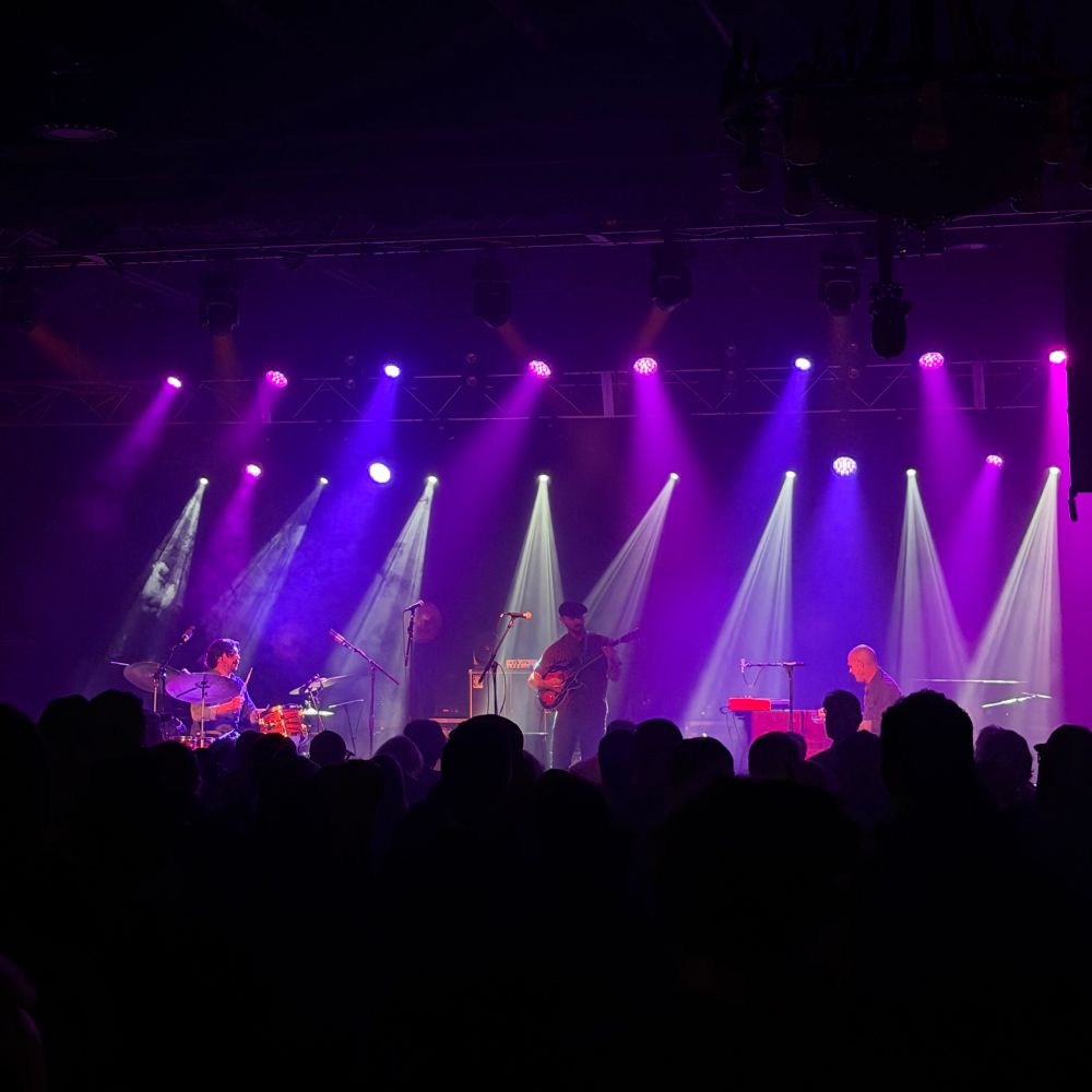 Photo of the band Norside Organ Trio performing at Higher Ground in South Burlington, VT. The lighting on stage is a mix of purples, blues, pinks, and white lights. Is it blurry? Yeah kinda.