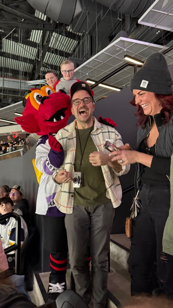 Friend being hugged by the Indy Fuel hockey team mascot and laughing