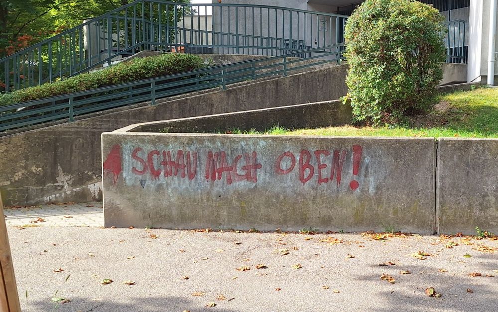 "Schau nach oben" auf einer Hausmauer gesprüht.